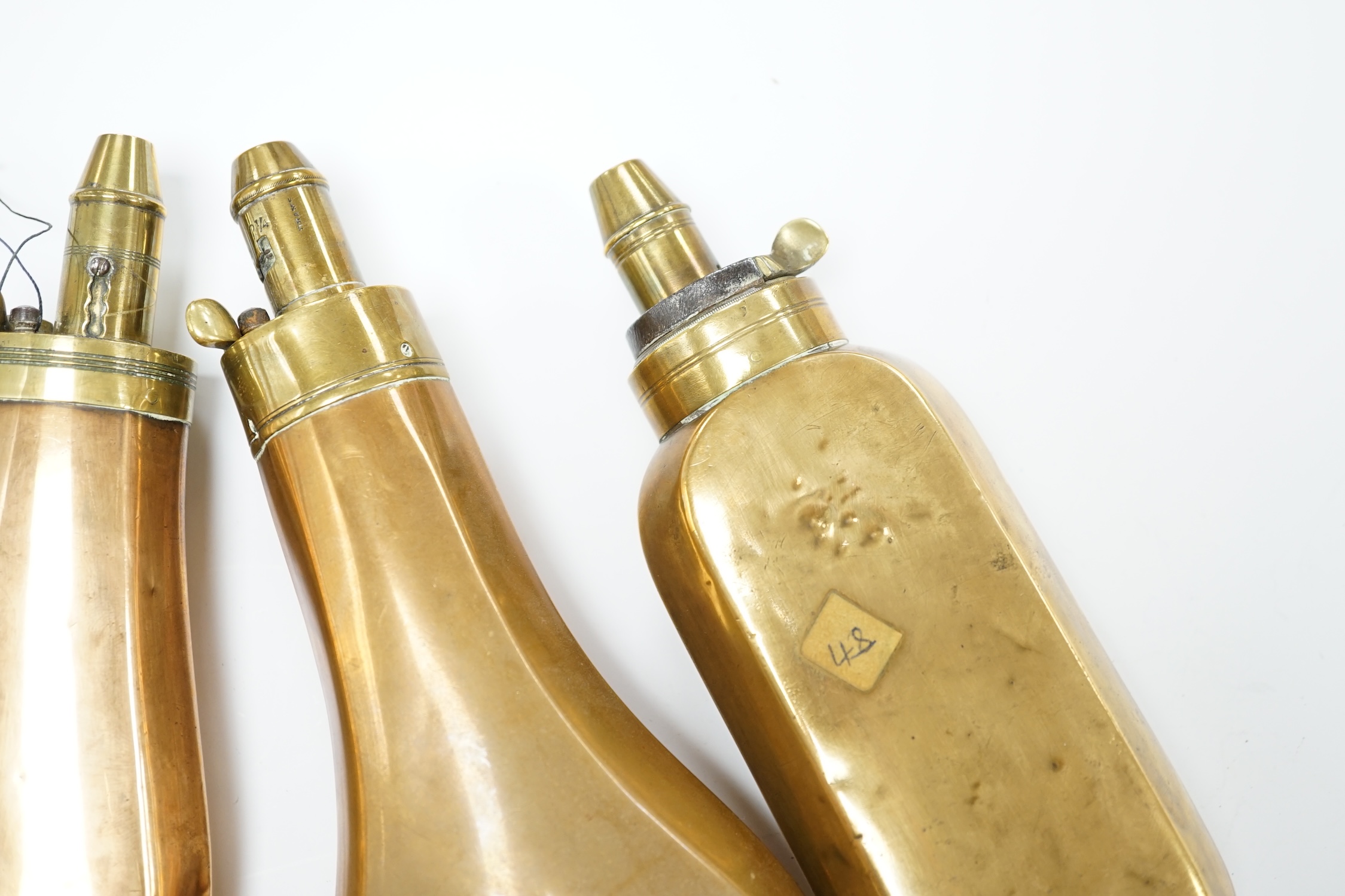 Five 19th century copper and brass powder flasks, all with plain copper bodies. Condition - fair